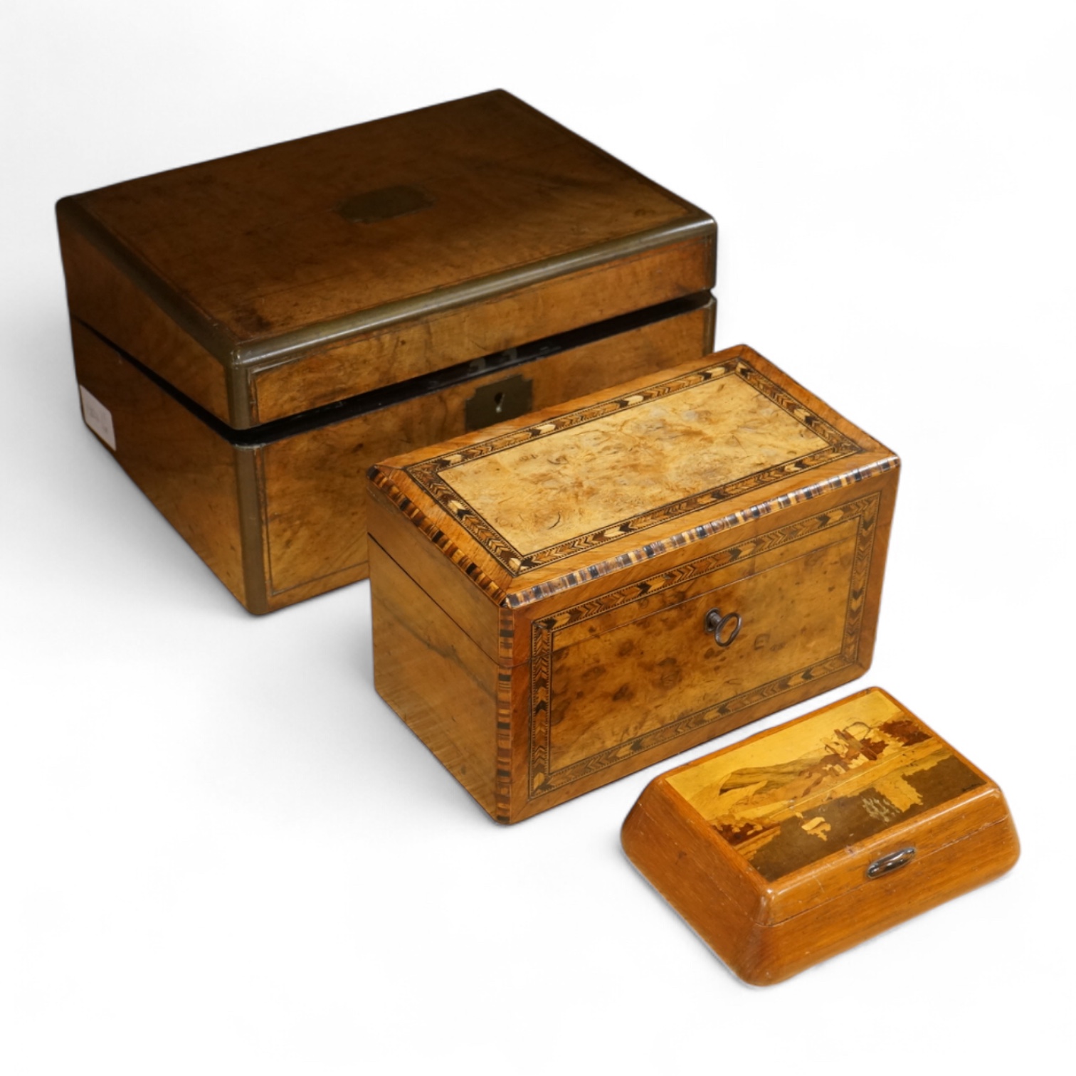 A walnut and German bandwork tea caddy, a brass bound walnut writing slope and an Art Deco Killarney inlaid trinket box, largest 15cm high, 30cm wide.